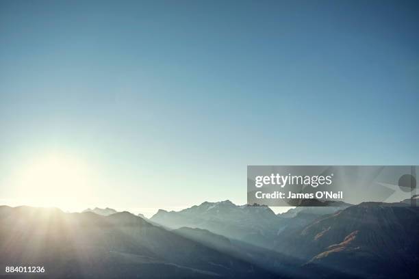 sunrise over mountain range and clear skies - wolkenloser himmel stock-fotos und bilder