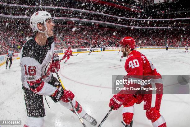 Steven Santini of the New Jersey Devils battles in the corner with Henrik Zetterberg of the Detroit Red Wings during an NHL game at Little Caesars...