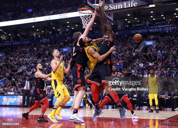 Cory Joseph of the Indiana Pacers passes the ball as Jakob Poeltl and Pascal Siakam of the Toronto Raptors defend during the first half of an NBA...
