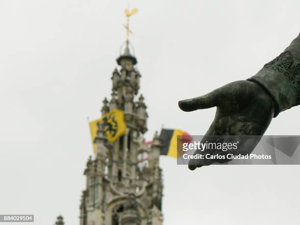 hand of sculpture showing the flags of belgium and flanders in antwerp - belgian culture stockfoto's en -beelden