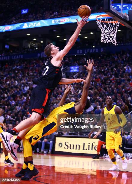 Jakob Poeltl of the Toronto Raptors shoots the ball as Thaddeus Young of the Indiana Pacers defends during the second half of an NBA game at Air...