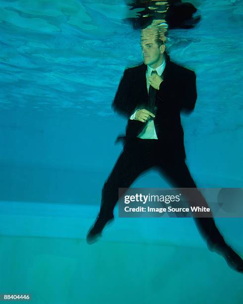 a man adjusts his tie under the water. - adjusting blue tie stock-fotos und bilder