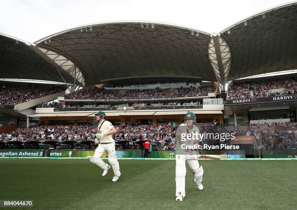 Cameron Bancroft and David Warner of Australia walk out to bat during day one of the Second Test match during the 2017/18 Ashes Series between...