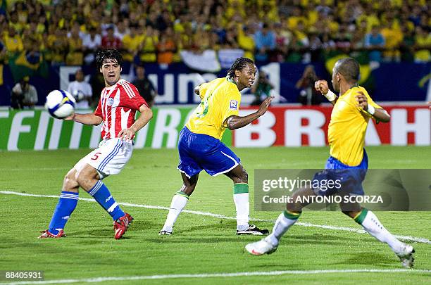 Brazilian striker Robinho shoots to score past Paraguay's Julio Caceres as Brazil's Kleber looks on during their FIFA World Cup South Africa 2010...