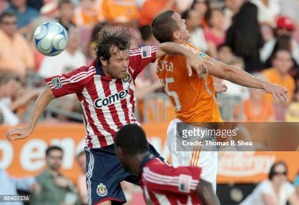 Cam Weaver of the Houston Dynamo heads the ball over Carey Talley of Chivas USA at Robertson Stadium on June 10, 2009 in Houston, Texas.