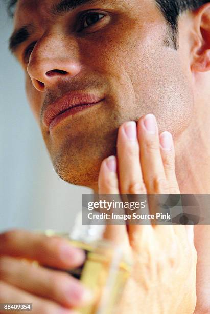 applying aftershave - pets stockfoto's en -beelden