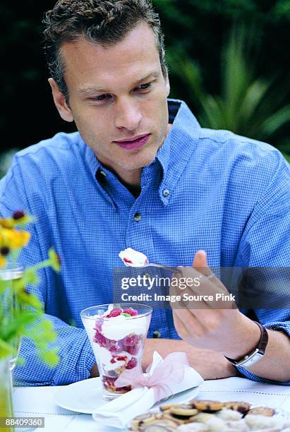 man eating dessert - mangiare stockfoto's en -beelden