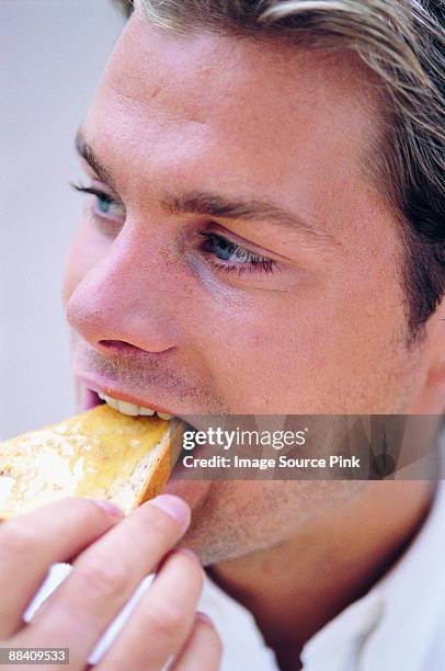 man eating toast - mangiare fotografías e imágenes de stock
