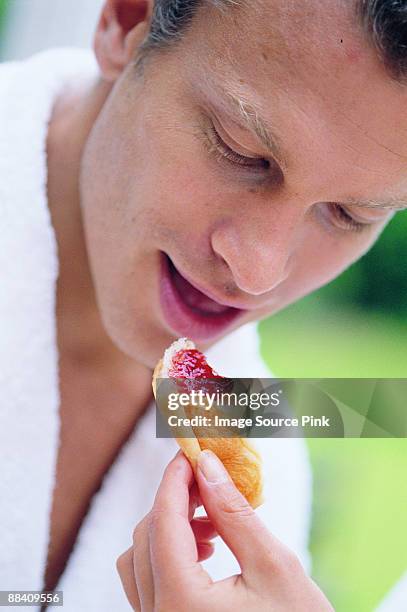 man eating croissant - mangiare fotografías e imágenes de stock