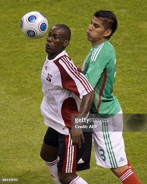 Mexican Carlos Salcido vies for the ball with Trinidad and Tobago's Keon Daniel during their FIFA World Cup South Africa-2010 qualifier at the Aztec...