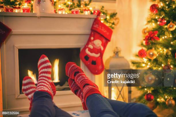erwärmung und entspannen in der nähe von kamin für das weihnachtsgeschäft - feet christmas stock-fotos und bilder