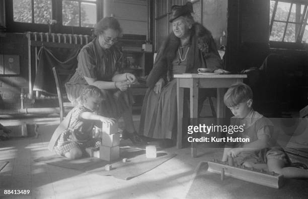 Italian educationist and founder of the Montessori Schools, Maria Montessori , watching pupils in class at a school in Acton, London, 2nd November...