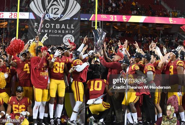 Head coach Clay Helton of the USC Trojans holds up the trophy with his team after they beat the Stanford Cardinal 31-28 in the Pac-12 Football...