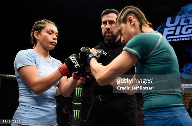 Opponents Nicco Montano and Roxanne Modafferi receive instructions from referee John McCarthy prior to their women's flyweight championship bout...