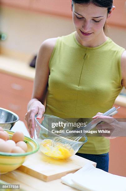 woman preparing omelette - cucinare fotografías e imágenes de stock