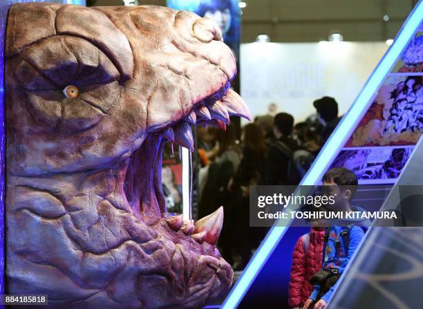 Visitors look at a monster head displayed at the Valerian booth at Tokyo Comic Con 2017 at Makuhari Messe in Chiba on December 2, 2017. The second...