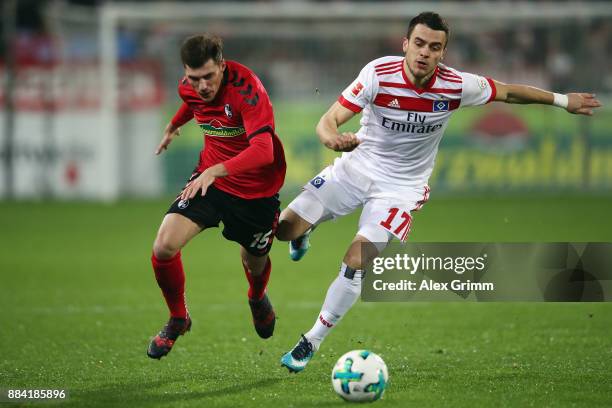 Filip Kostic of Hamburg is challenged by Pascal Stenzel of Freiburg during the Bundesliga match between Sport-Club Freiburg and Hamburger SV at...