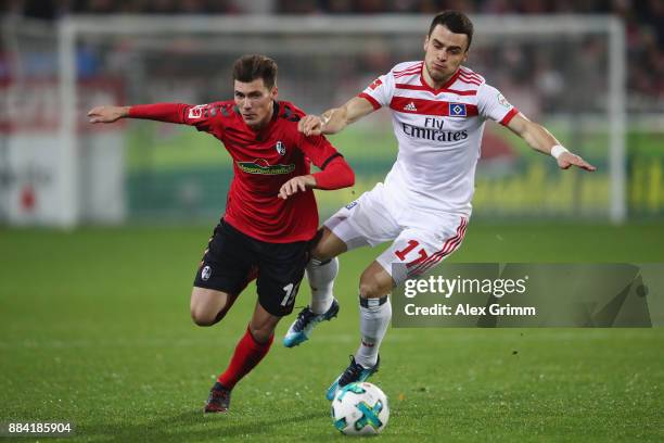 Filip Kostic of Hamburg is challenged by Pascal Stenzel of Freiburg during the Bundesliga match between Sport-Club Freiburg and Hamburger SV at...