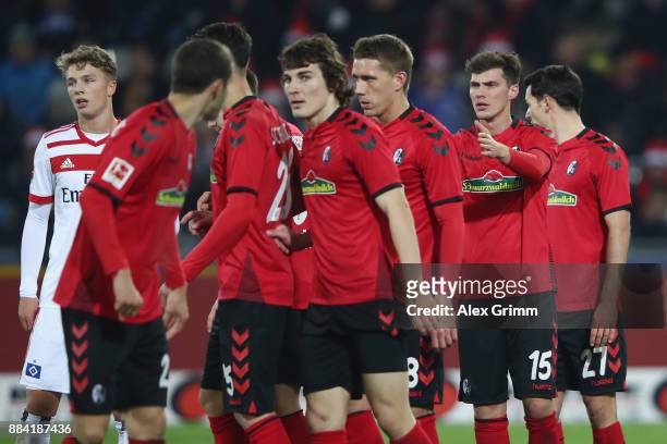 Pascal Stenzel of Freiburg directs the wall before a free-kick during the Bundesliga match between Sport-Club Freiburg and Hamburger SV at...