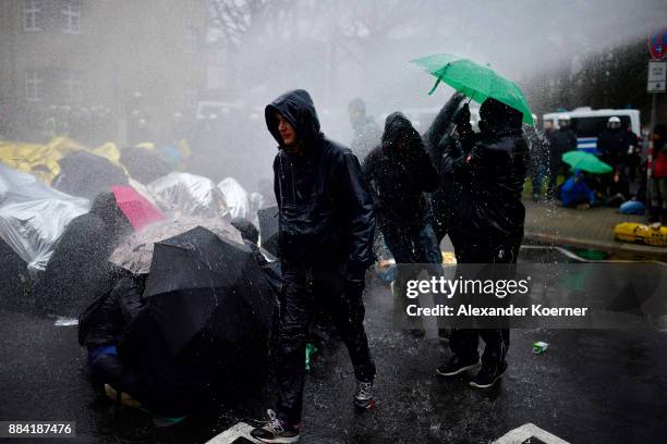 Left-wing protesters get sprayed by a water cannon as they clash with police forces outside the Hannover Congress Centrum prior to today's AfD...