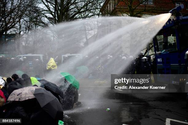 Left-wing protesters get sprayed by a water cannon as they clash with police forces outside the Hannover Congress Centrum prior to today's AfD...