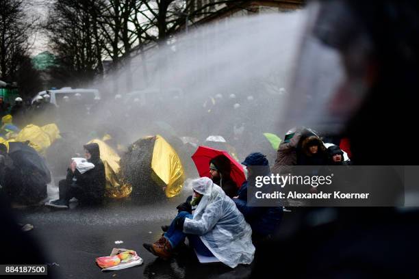 Left-wing protesters get sprayed by a water cannon as they clash with police forces outside the Hannover Congress Centrum prior to today's AfD...