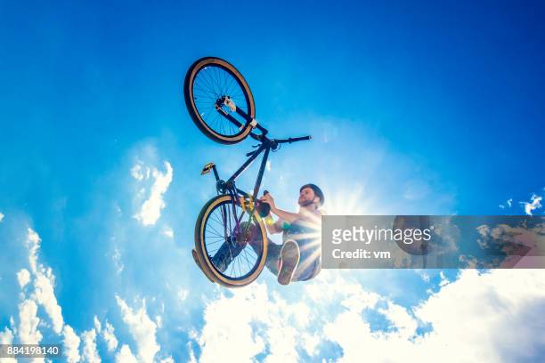 空気中のトリックをやってるフリー スタイル bmx サイクリスト - スタントバイク ストックフォトと画像