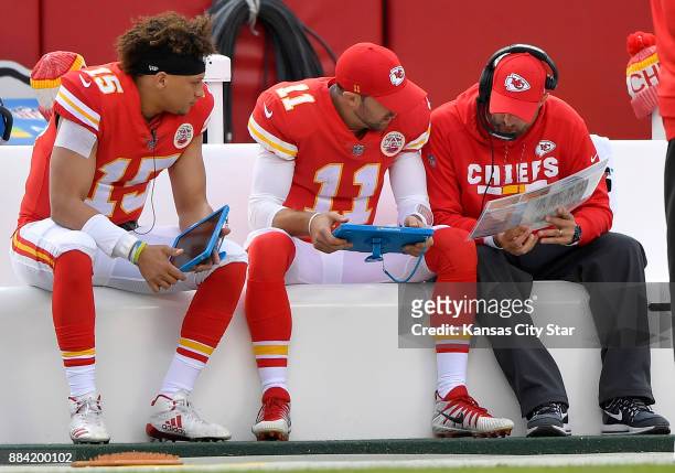 Kansas City Chiefs quarterback Alex Smith goes over plays on the bench as backup quarterback Patrick Mahomes looks on during a game against the...