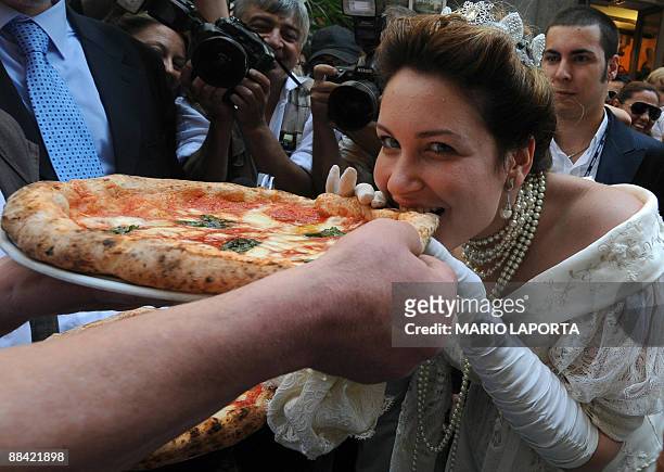 An actress dressed like Queen Margherita of Savoy tastes a pizza named after her during a ceremony to celebrate the 120th anniversary of the pizza...