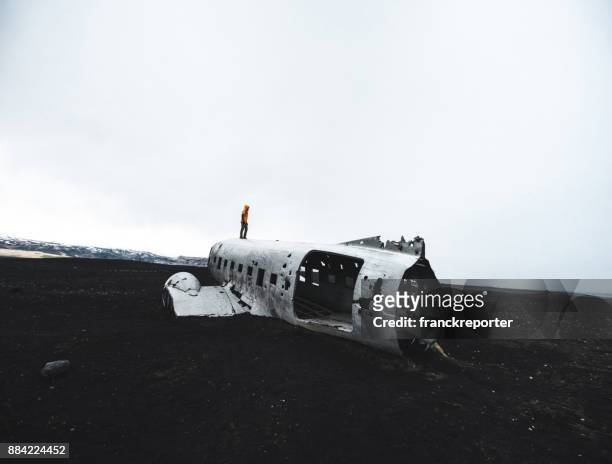 man alone on the airplane wreck in iceland - carcass island stock pictures, royalty-free photos & images