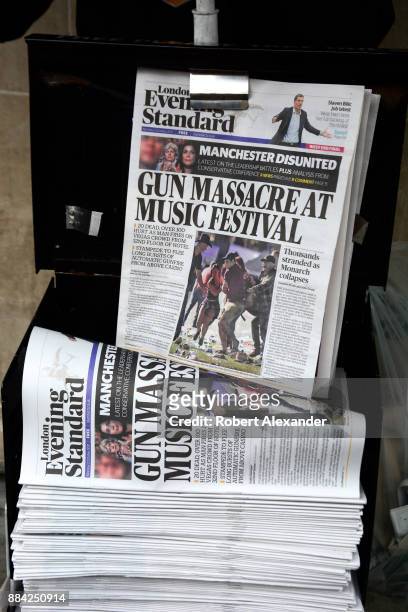 Stack of London Evening Standard newspapers being distributed at a street corner in London, England. The headline refers to a mass murder the...