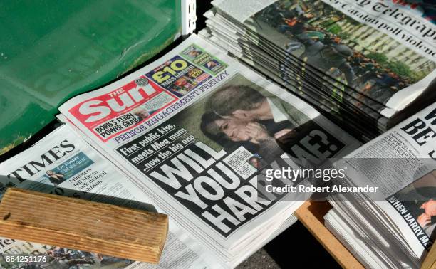 Variety of daily newspapers, including The Sun, for sale at a newstand in London, England. The Sun's headline refers to Prince Harry and his...