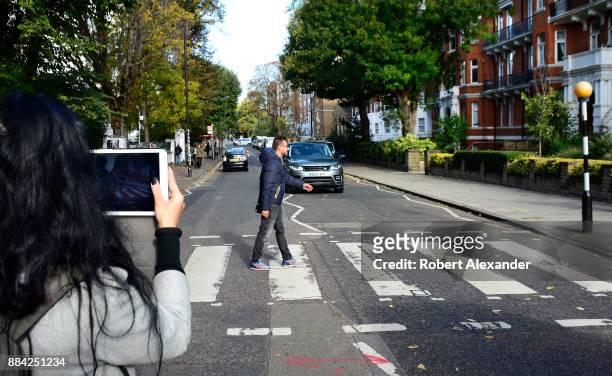 Beatles fan is photographed as he walks across Abby Road in London, England, recreating the famous 1969 Beatles 'Abby Road' album cover photograph...