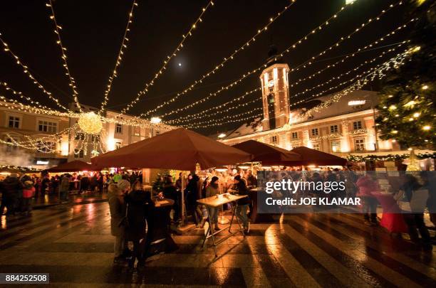 People gather at the Christmas market on December 1, 2017 in Sankt Poelten, west of the capital Vienna. / AFP PHOTO / JOE KLAMAR