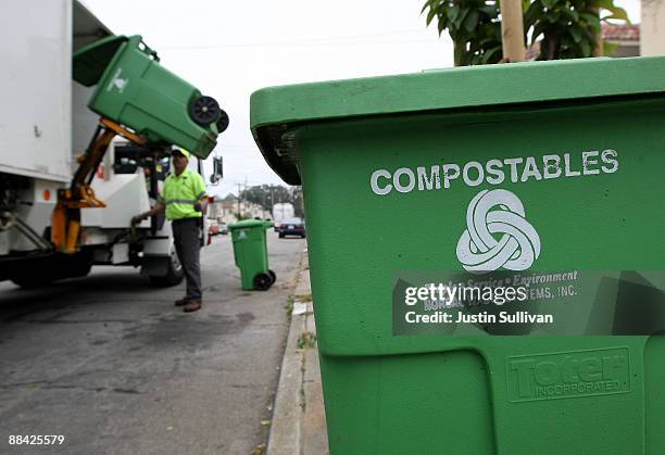 Norcal Waste worker Manuel Vera dumps a bin with compostable materials into a truck while collecting recyclable materials in a Sunset district...