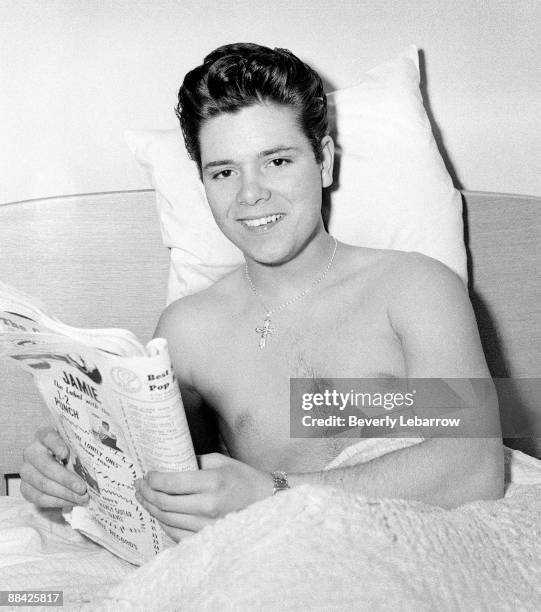 Photo of Cliff RICHARD; posed, lying in bed, reading magazine, c.1958/1959