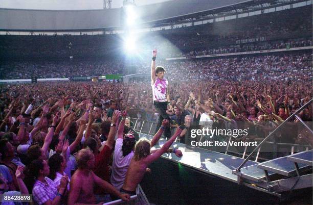 11th AUGUST: Mick Jagger from The Rolling Stones performs live on stage walking down gantry in arena/stadium with crowds/audience surrounding him...