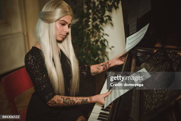 woman reading notes and playing piano - performing arts occupation stock pictures, royalty-free photos & images