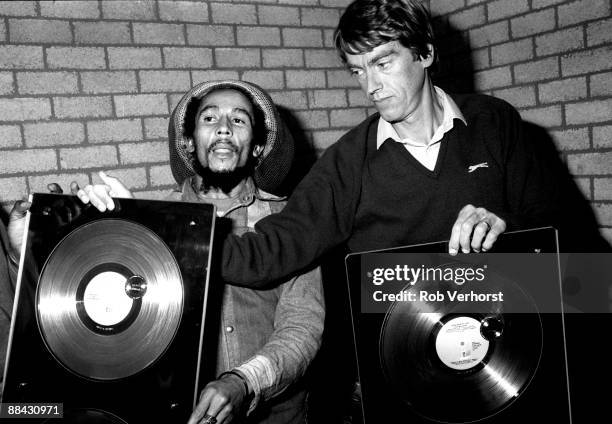 Photo of Bob MARLEY, posed in dressing room with Anton Witkamp of Warner Music receiving award for Babylon By Bus