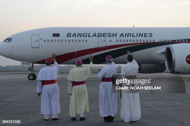 Cardinals wave goodbye to a Bangladesh airlines aircraft carrying Pope Francis after his three-day visit to Bangladesh, in Dhaka on December 2, 2017....