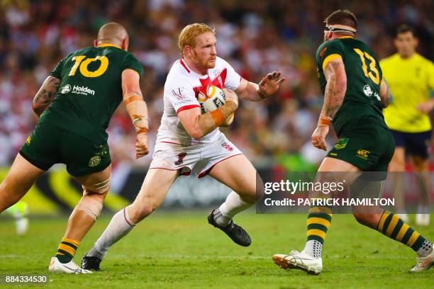 James Graham of England runs tries to avoid David Klemmer and Josh McGuire of Australia during the rugby league World Cup men's final match between...