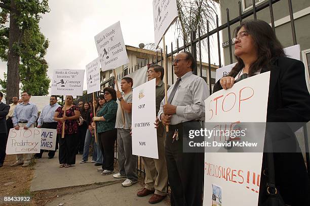 Activists hold signs in front of an apartment building where all of its four families are facing eviction during a press conference in the community...