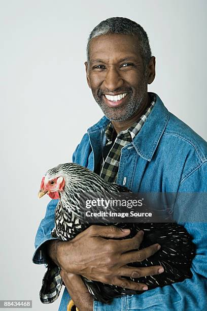 man holding a chicken - un seul animal photos et images de collection