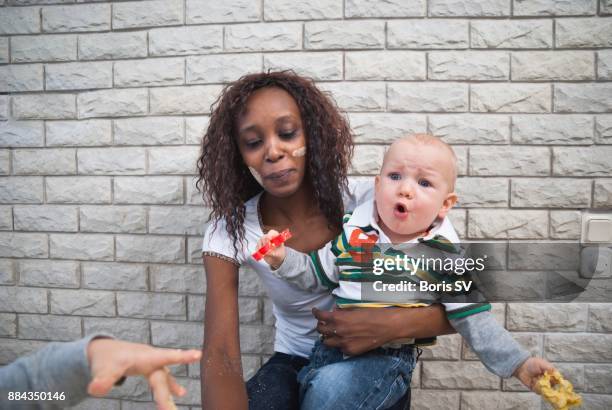 nanny taking care of restless brothers - nanny smiling stockfoto's en -beelden