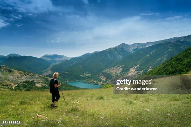 frau bewundert seeblick in italienischen bergen - abruzzi stock-fotos und bilder