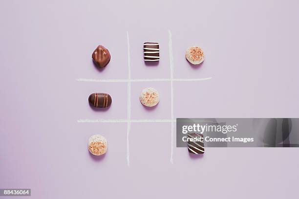 chocolates on grid - tic tac toe stock pictures, royalty-free photos & images