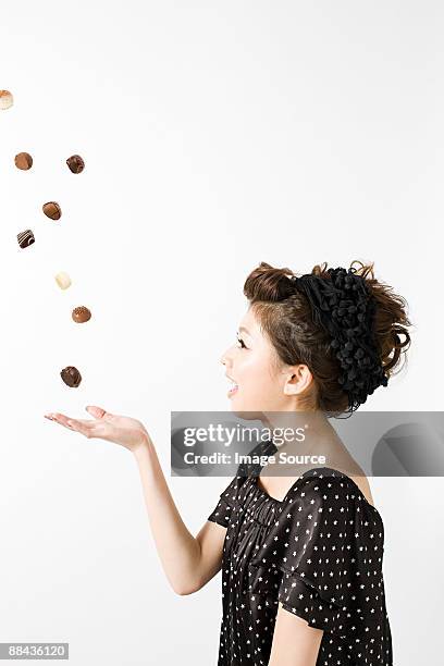 woman with falling chocolates - catching food stock pictures, royalty-free photos & images