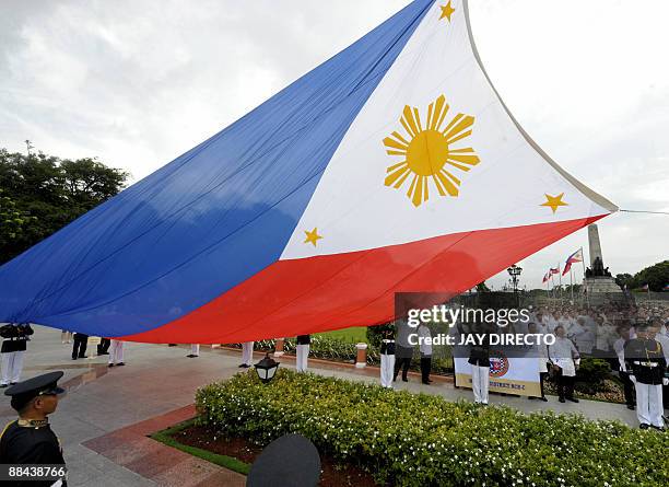 Government officials lead a flag-raising ceremony at Manila's Luneta park on June 12 to celebrate the 111th anniversary of the declaration of...