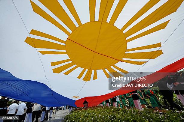 Government officials lead a flag-raising ceremony at Manila's Luneta park on June 12 to celebrate the 111th anniversary of the declaration of...