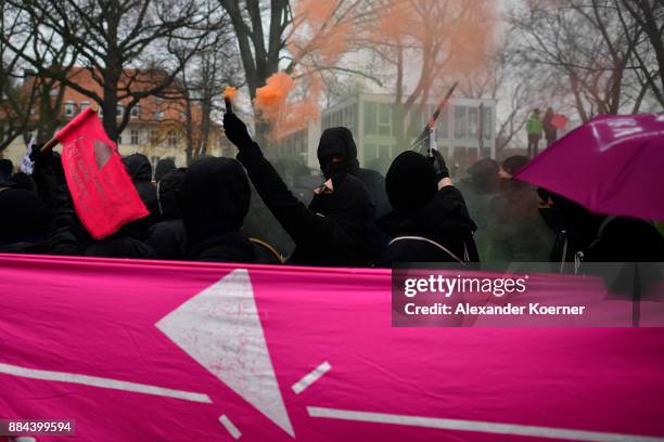 Left-wing protesters burn colour flares during a protest march during todays AfD federal congress at the Hannover Congress Centrum on December 2,...